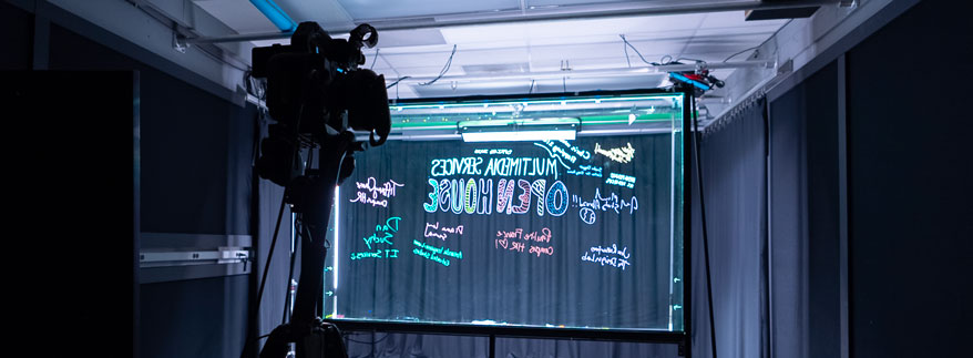 Photo of the large learning glass in Studio A with multicolored writing